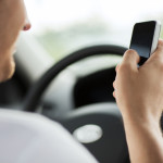 man using phone while driving the car