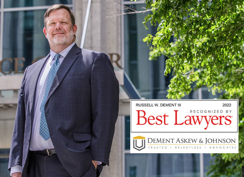 Russell W. Dement standing next to tha badge recognizing hislisting in Best Lawyers 2022